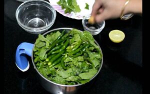 Firstly add coriander leaf, mint leaf and green chilis into the jar.